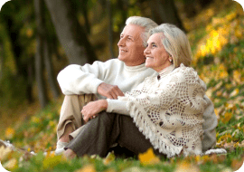 elderly couple sitting on a grassland outdoors