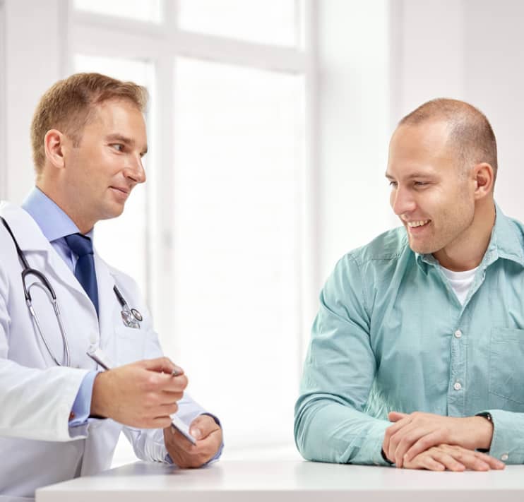 img - male-doctor-and-patient-with-clipboard-at-hospital