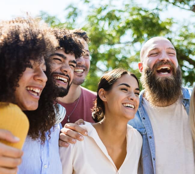 male and female group of friends smiling for a photo outdoors
