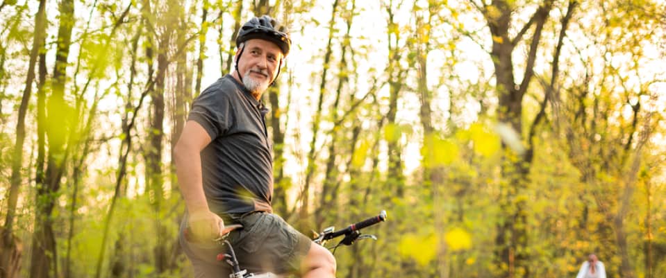 elderly man biking in the woods