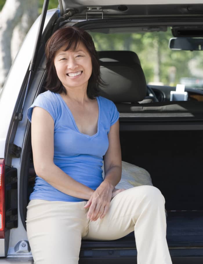 img - woman-sitting-in-back-of-van-smiling